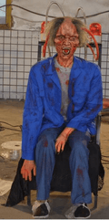 zombie animatronic in electric chair with flashing lights and head wires