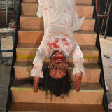 female ghost animatronic crawling down staircase with blood-stained face