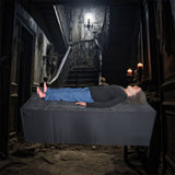 female corpse animatronic lying on platform in haunted morgue setting
