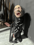 Bound screaming zombie prop tied to frame for haunted house torture scene
